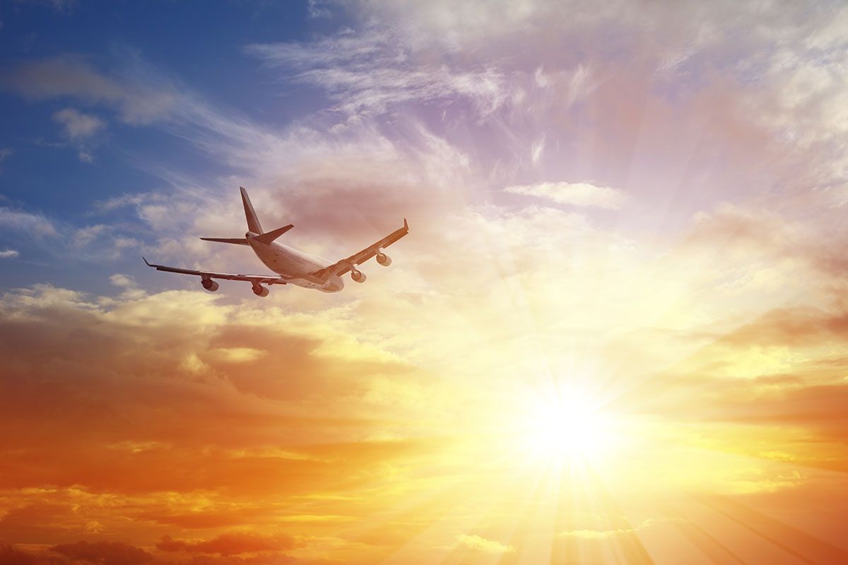 Airplane Flying Under Sunset